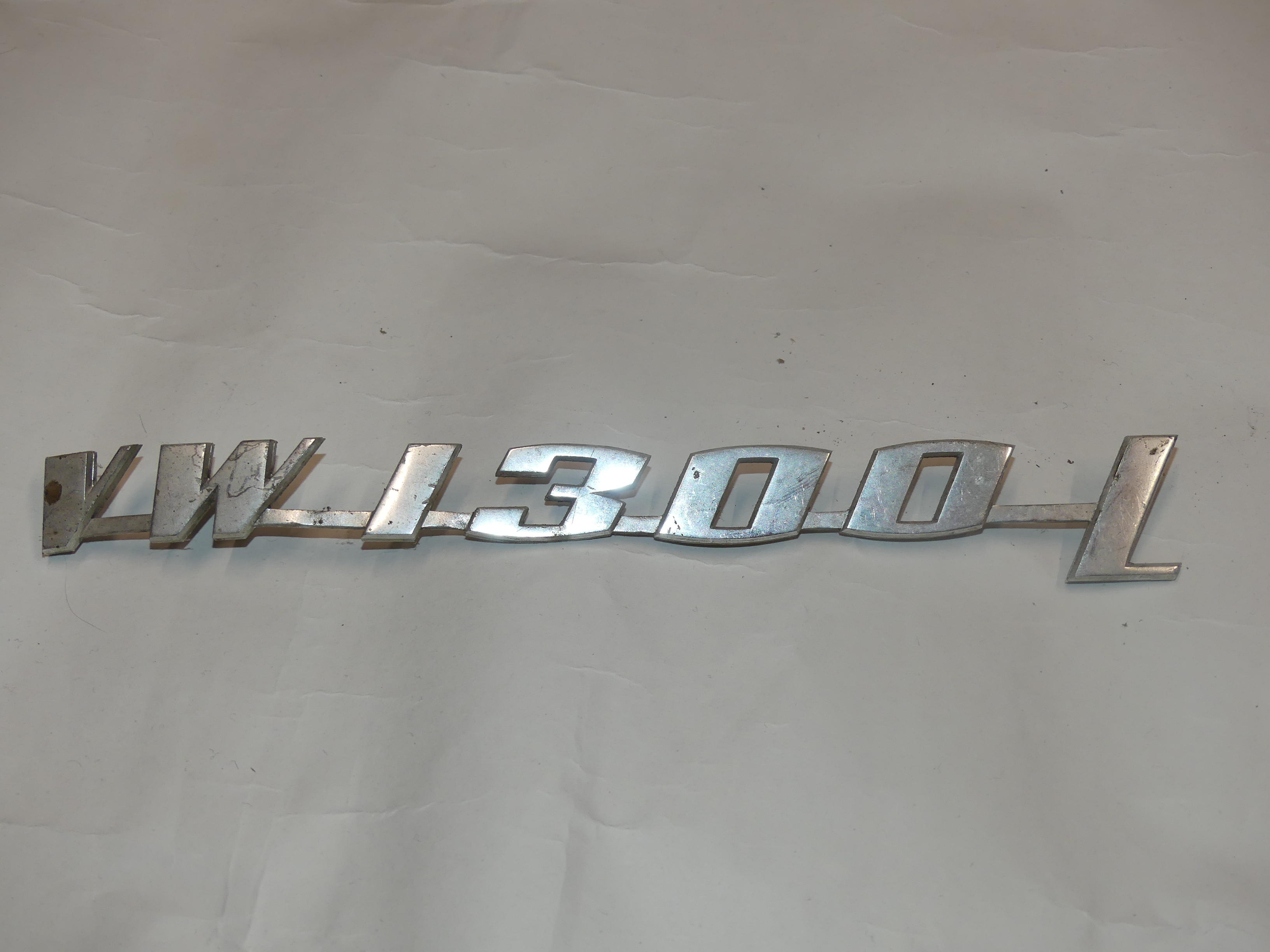 Schriftzug "VW 1300 L", glatte Oberfläche (Gebrauchtteil)
